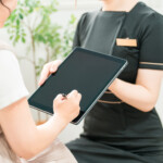 カウンセリングで聞くべき質問がまとめられたチェックリストと、メモを取る手元①