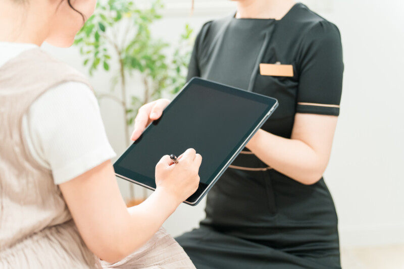 カウンセリングで聞くべき質問がまとめられたチェックリストと、メモを取る手元①