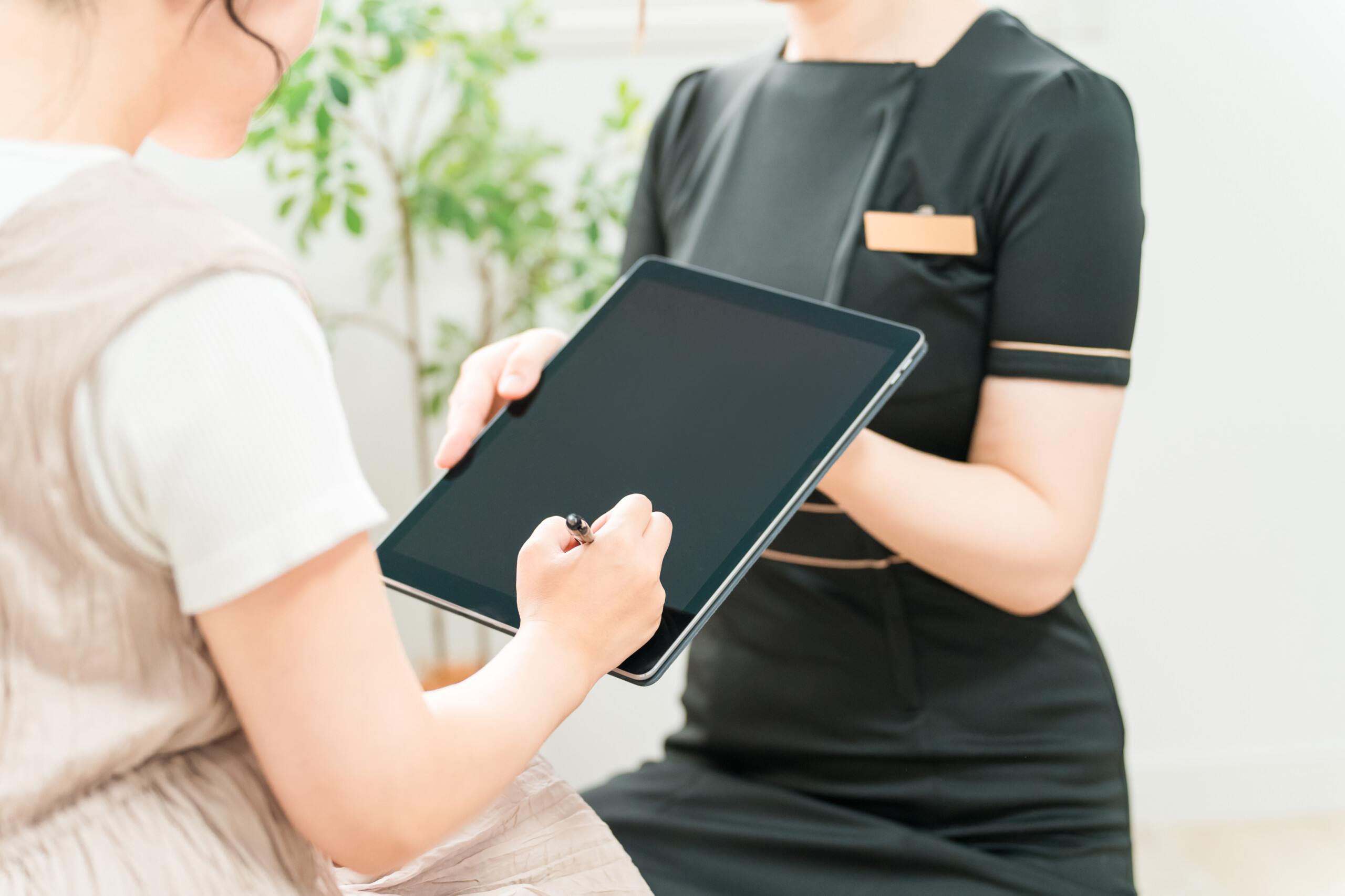 カウンセリングで聞くべき質問がまとめられたチェックリストと、メモを取る手元