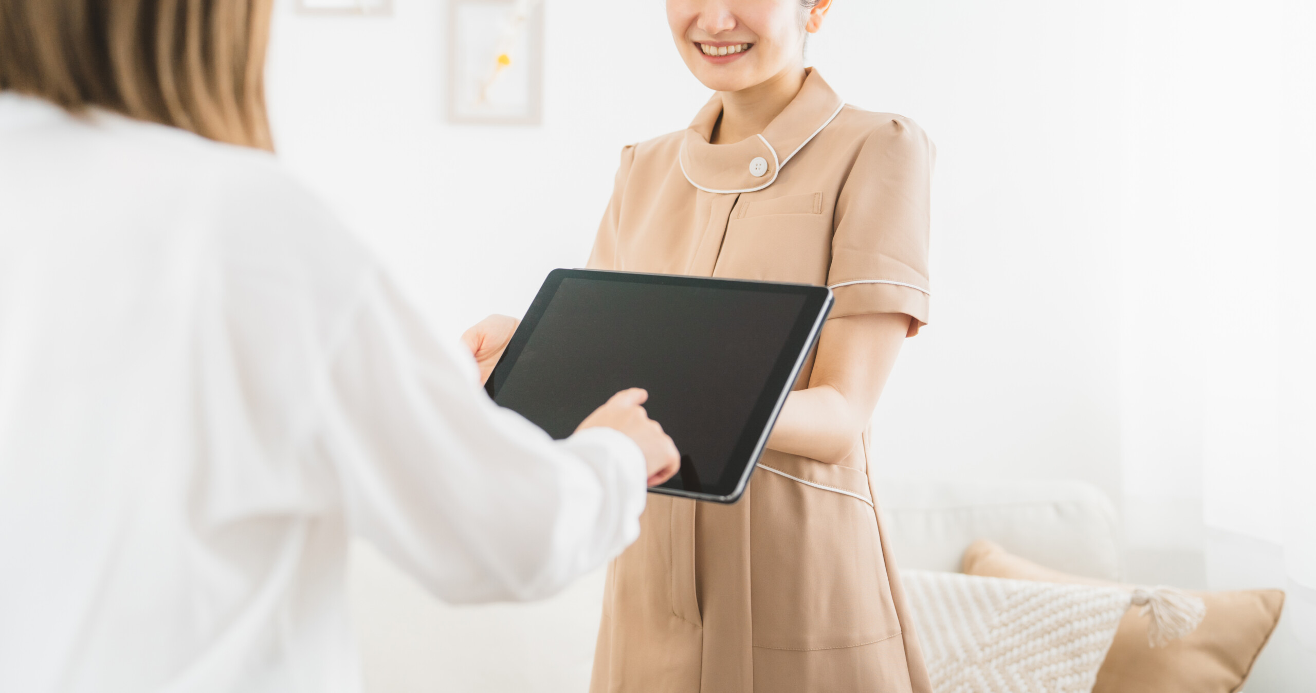 料金表を説明するサロンスタッフと、料金について相談するお客様の様子